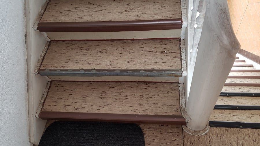 Treppenhaus mit ökologischem Linoleumbelag — Nahsicht dreier freigelegter Stufen am Handlauf