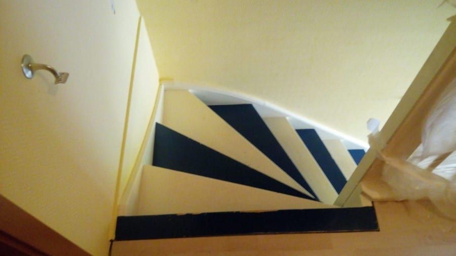Holztreppe abgeschliffen und neu lackiert — vorher: das Podest mit blau-weiß gestrichenen Keilstufen