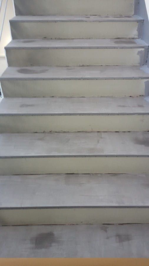 Fluchttreppenhaus mit Kautschukformtreppen — Nahsicht der unbehandelten Betonkanten von unten