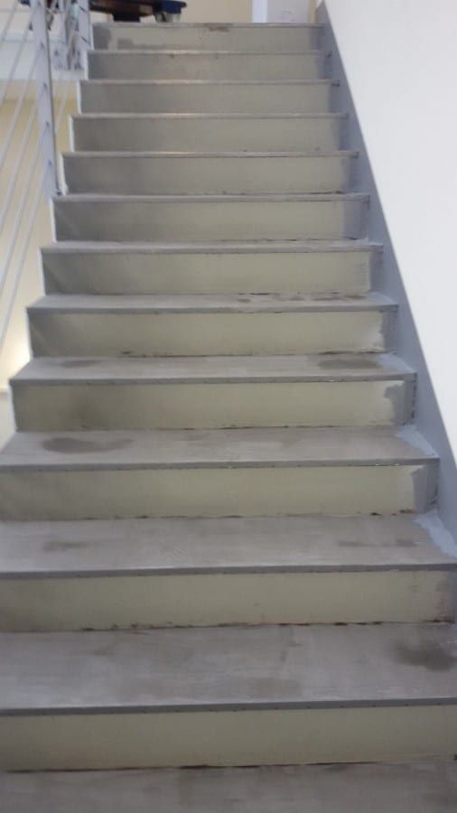 Fluchttreppenhaus mit Kautschukformtreppen — Blick den unbehandelten Lauf hinauf, Stahlgeländer rechts