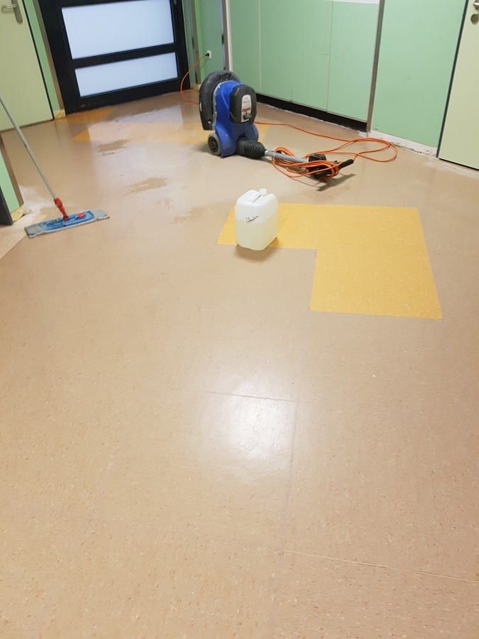 Alte Bodenbeläge im Gewerbe entfernt — der alte Belag im Klinikflur wird eingeweicht