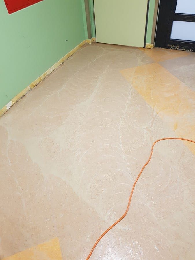 Alte Bodenbeläge im Gewerbe entfernt — Nahsicht der Fläche mit den Klebstoffresten vor der Tür