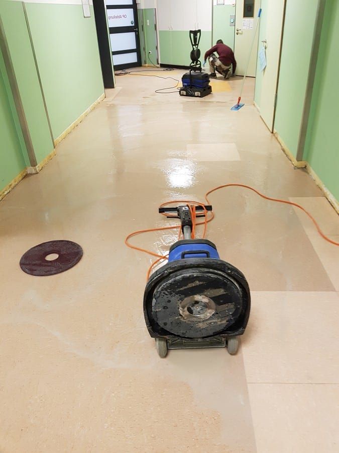 Alte Bodenbeläge im Gewerbe entfernt — die Bodenmaschine im Flur vor der Glastür