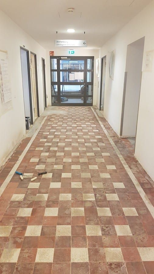 Neue Bodenbeschichtung, schichtweiser Aufbau — der alte Karo-Belag im Flur vor dem Abtrag