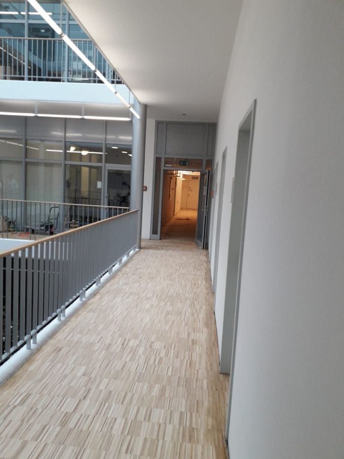 Eiche-Hochkantlamelle geschliffen und lackiert — Galeriegang neben der Glaswand