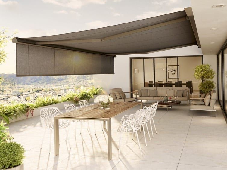 Gelenkarmmarkise über der Terrasse — graugrünes Tuch über der Dachterrasse mit langer Tafel