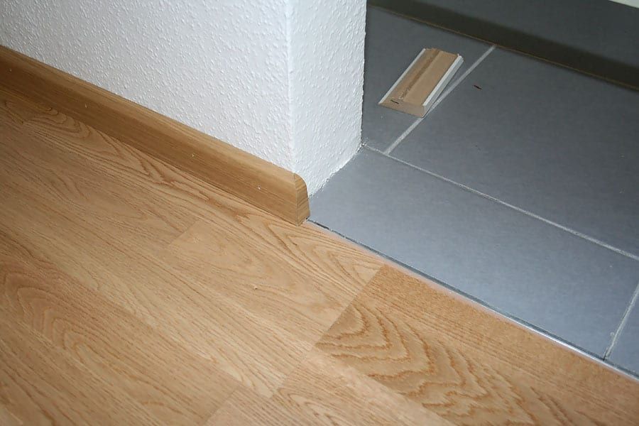 Wohnungsrenovierung mit Fertigparkett Eiche — montierte Sockelleiste an der Ecke zum Fliesenboden