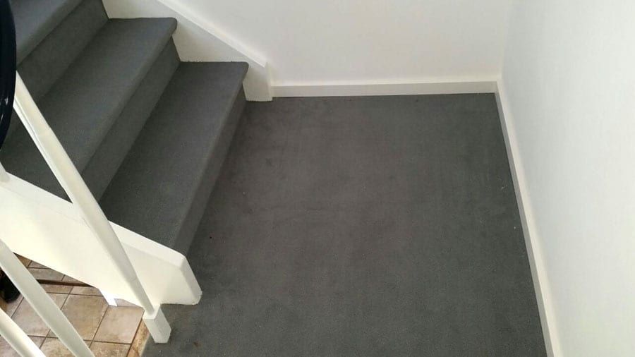 Holztreppe mit hochwertigem Textilbelag — Podest mit dem Belag bis an den Wandanschluss