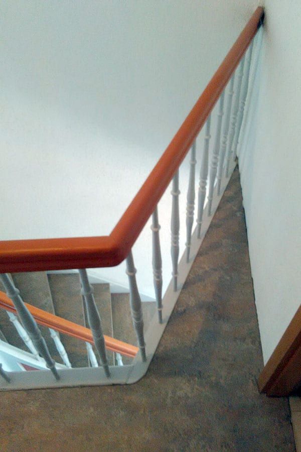 Treppenhausstufen mit Linoleum — Handlauf und weißes Geländer über dem Treppenauge